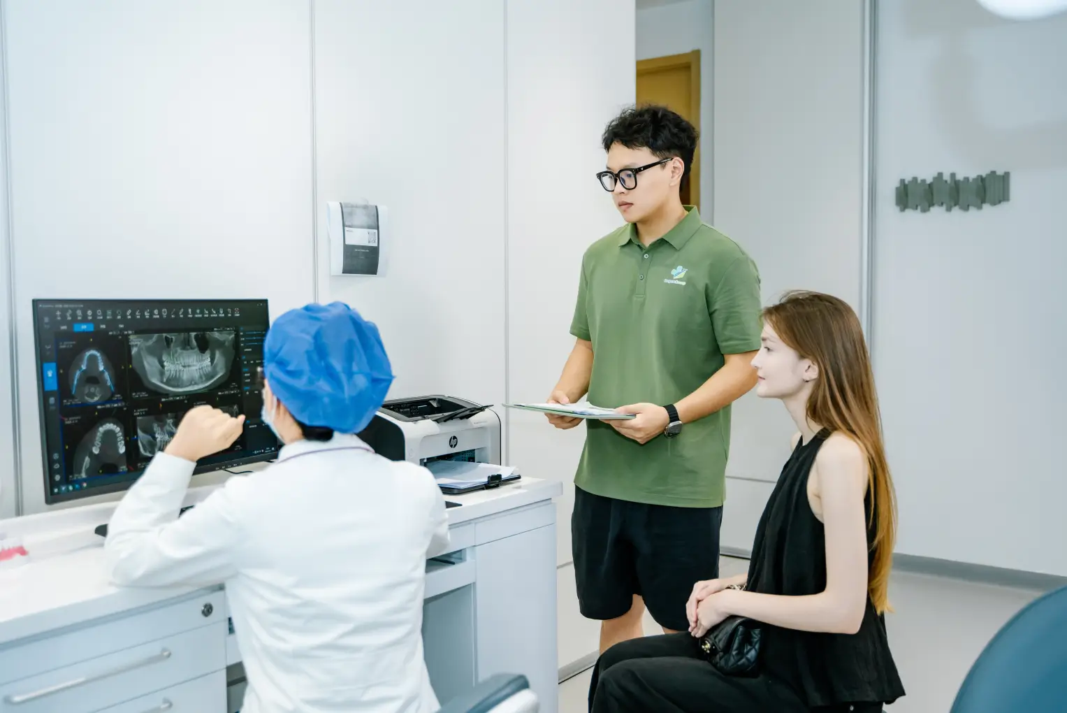 Patient and care coordinator reviewing dental imaging with a clinician